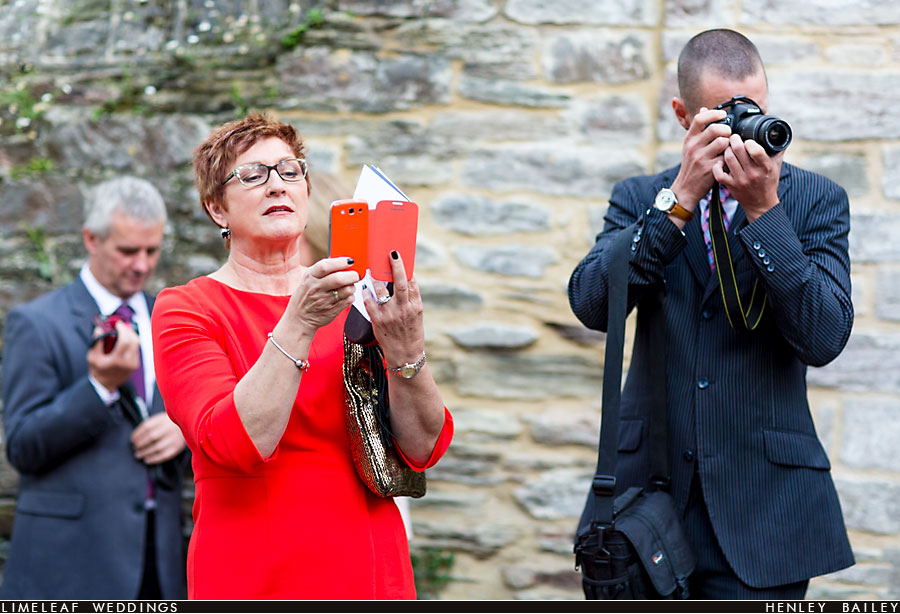 Guests photographing wedding couple
