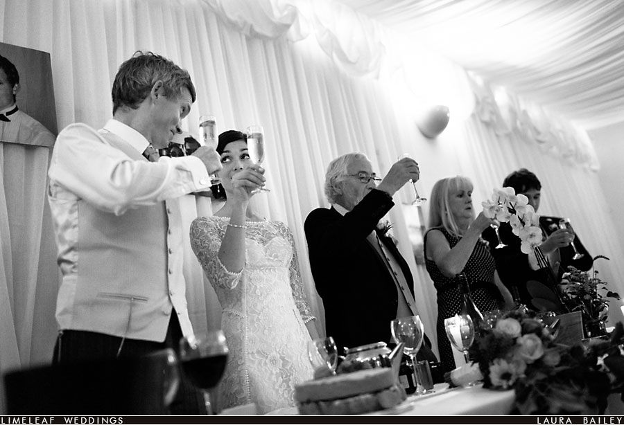 Bride and groom toast as they look at each other during their wedding speeches